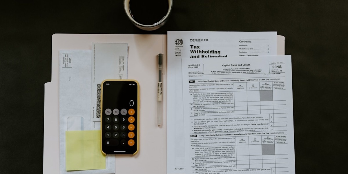 Calculator and tax documents on a wooden desk